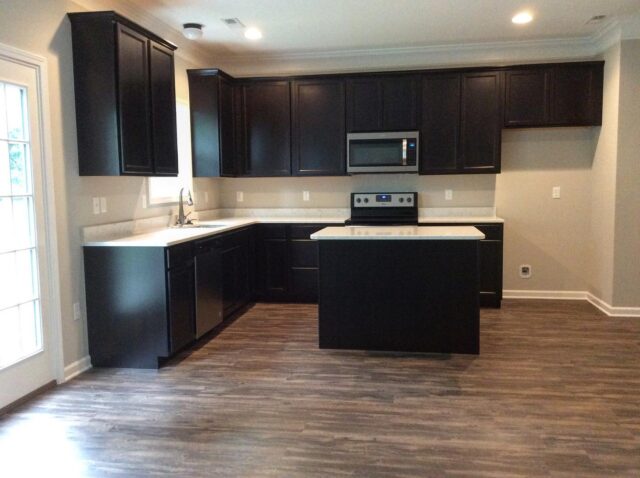 The Franklin kitchen with Sinclair Sarsaparilla cabinets, Minuet quartz, and Genoa LVP flooring #thefranklinbysmithbilt